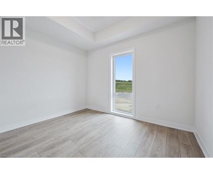 A room with a large window overlooking a field.