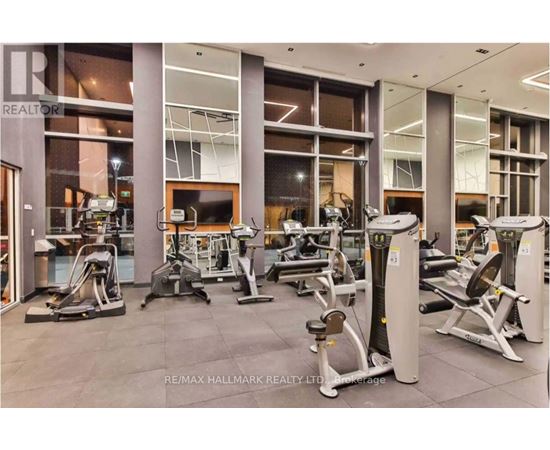 A gym with a variety of equipment including treadmills, weights, and exercise machines.