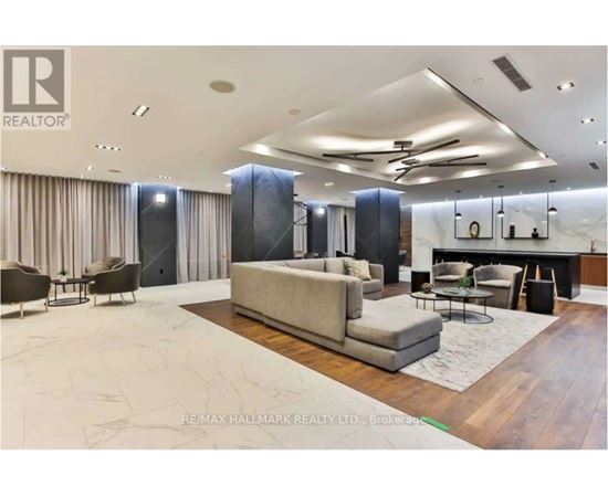 A spacious living room with a large couch and a dining table.