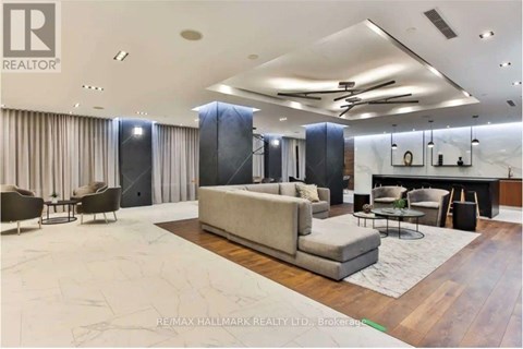 A spacious living room with a large couch and a dining table.