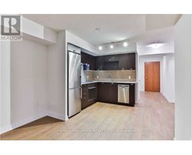 A kitchen with a refrigerator, oven, and dishwasher.