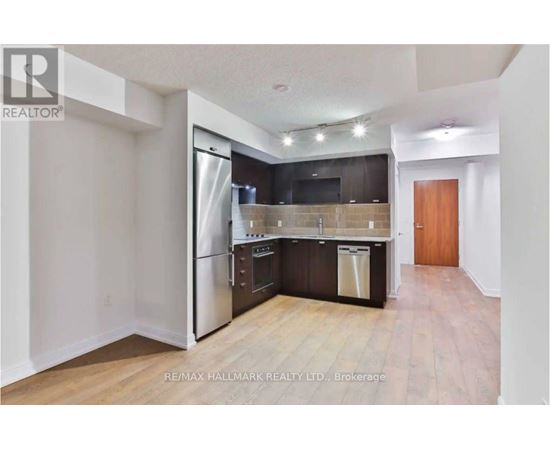 A kitchen with a refrigerator, oven, and dishwasher.