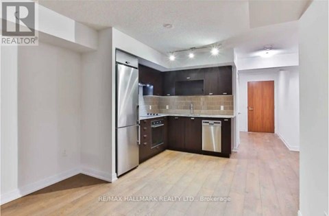 A kitchen with a refrigerator, oven, and dishwasher.