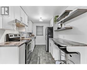 A modern kitchen with white cabinets and a wooden island.
