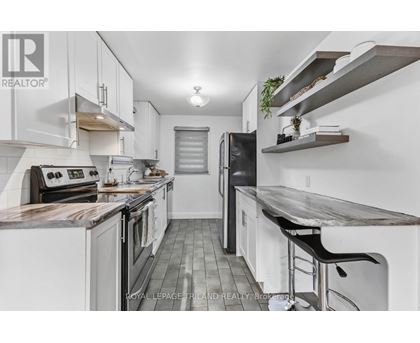 A modern kitchen with white cabinets and a wooden island.