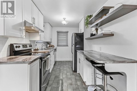 A modern kitchen with white cabinets and a wooden island.