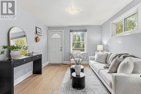 A well-lit living room with a grey couch and a black console table.