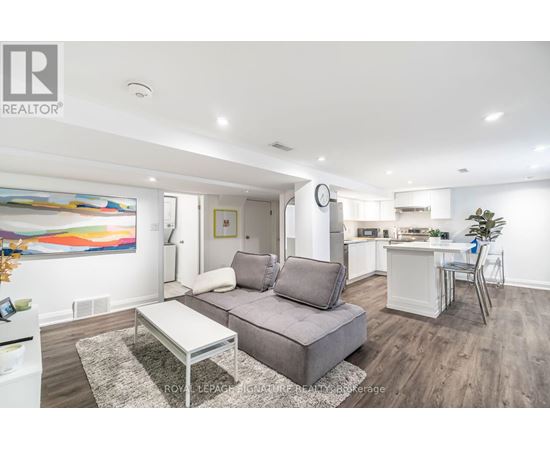 A modern living room with a grey sofa and a glass coffee table.