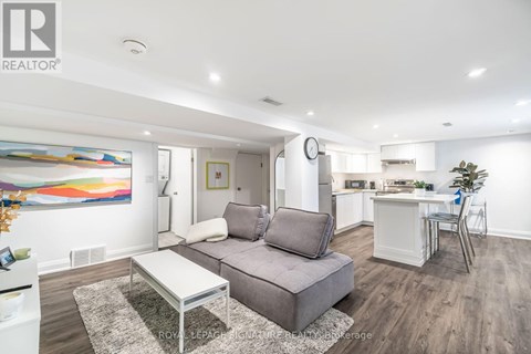 A modern living room with a grey sofa and a glass coffee table.