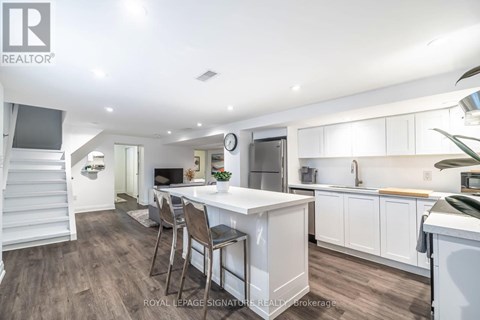 A well-lit kitchen with a dining table and chairs.