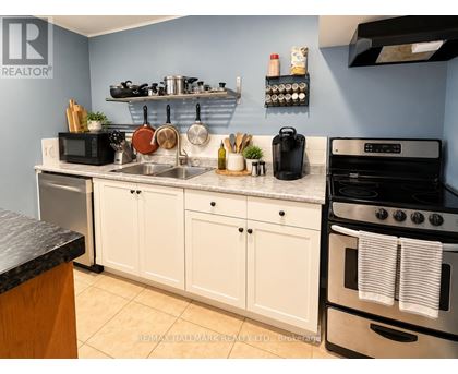 A kitchen with white cabinets and a black stove top oven.