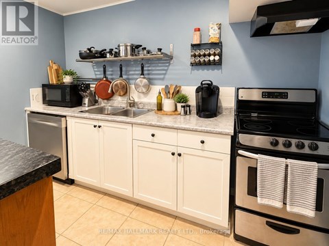 A kitchen with white cabinets and a black stove top oven.