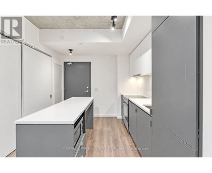 A kitchen with white countertops and grey cabinets.