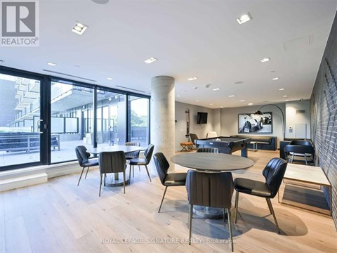 A modern dining room with a large table and chairs.