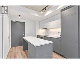 A modern kitchen with a white countertop and grey cabinets.