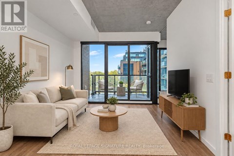 A living room with a couch, a coffee table, and a television.