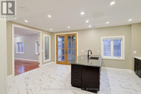 A spacious kitchen with a marble floor and a sink.