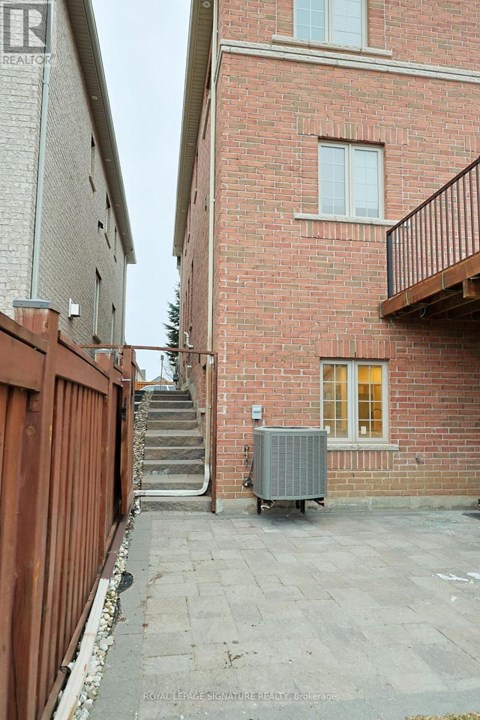 A red brick building with a balcony and a window.