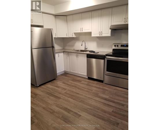 A kitchen with a stainless steel refrigerator, dishwasher, and oven.