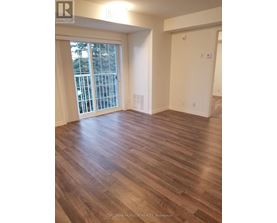 A room with wooden flooring and a sliding glass door leading to a balcony.