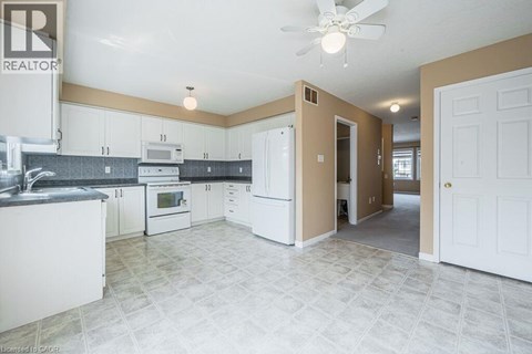 A kitchen with white cabinets and a tile floor.