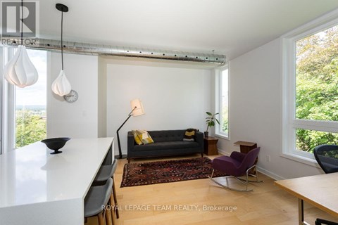 A living room with a black couch and a white table.