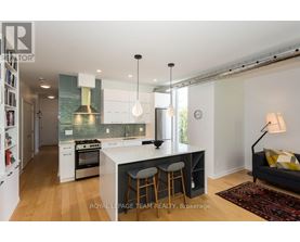 A kitchen with white cabinets and a black island.