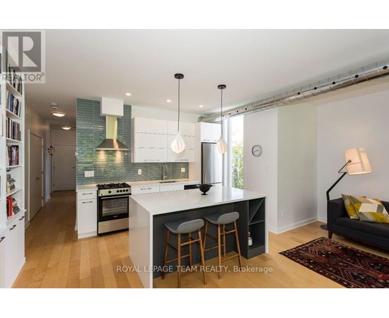 A kitchen with white cabinets and a black island.