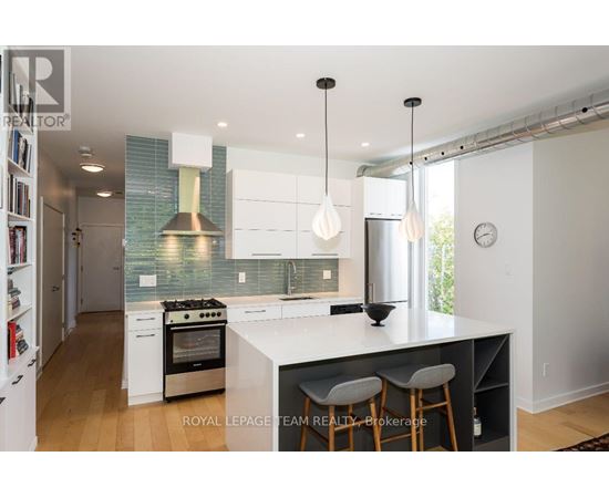 A modern kitchen with white cabinets and a large island.