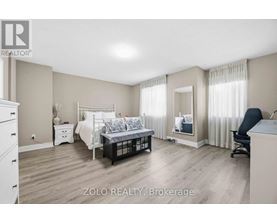 A bedroom with a bed, dresser, and chair.