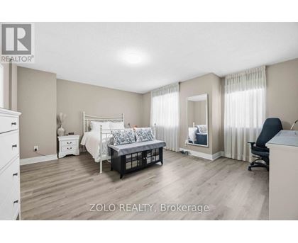 A bedroom with a bed, dresser, and chair.