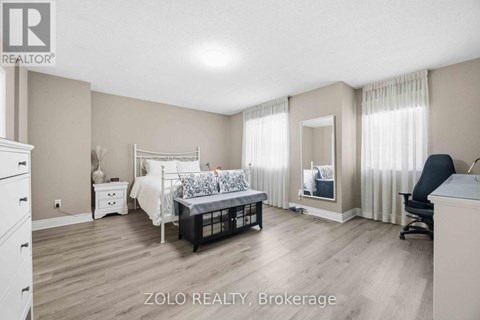 A bedroom with a bed, dresser, and chair.