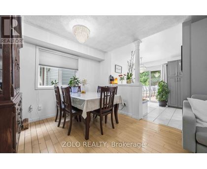 A dining room with a table set for six and a couch.