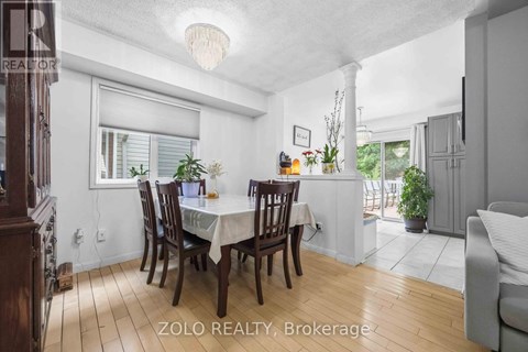 A dining room with a table set for six and a couch.