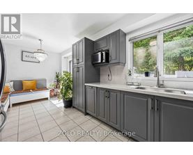 A kitchen with grey cabinets and a white countertop.