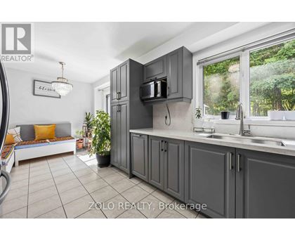 A kitchen with grey cabinets and a white countertop.