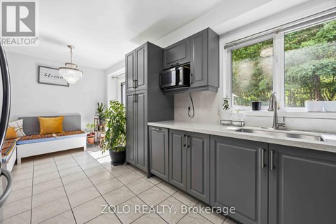 A kitchen with grey cabinets and a white countertop.
