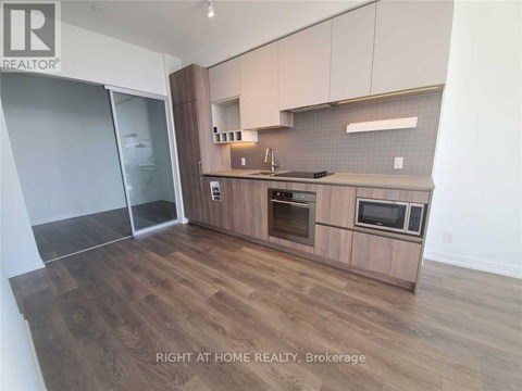 A kitchen with wooden floors and a countertop with a microwave and oven.