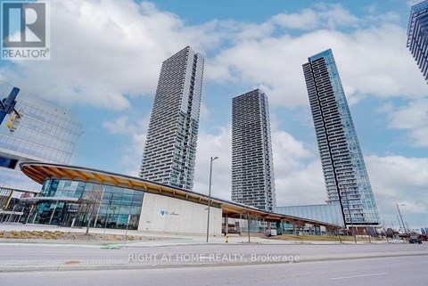 A modern building with a glass facade stands in front of a construction site.