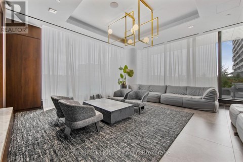 A modern living room with a grey sofa, a grey armchair, a grey coffee table, and a grey rug.
