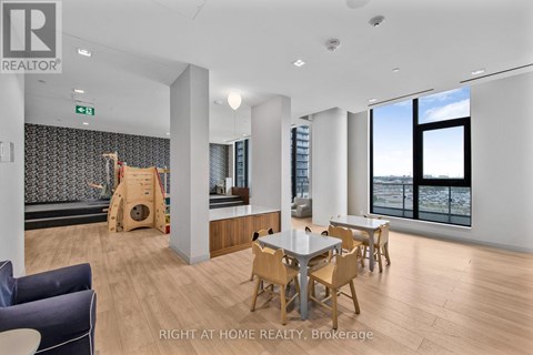 A spacious room with a dining table and chairs, a couch, and a play area with a slide.
