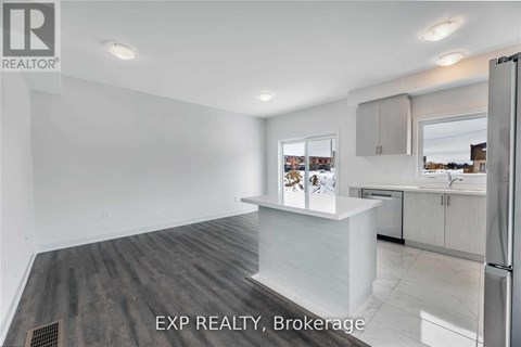A kitchen with white cabinets and a refrigerator.