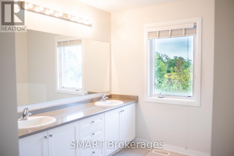 A bathroom with a window showing trees outside.