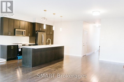 A modern kitchen with dark brown cabinets and a white island.
