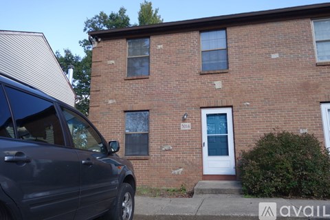 A brick house with a white door and windows.