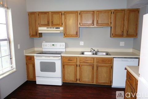 A kitchen with wooden cabinets and white appliances.