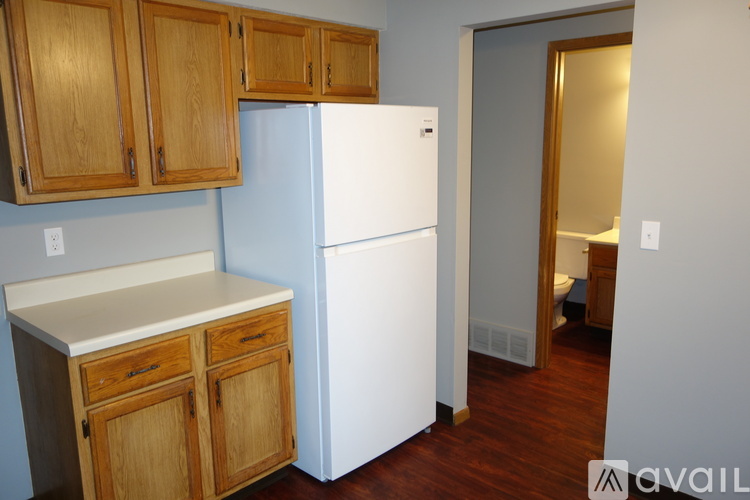 A kitchen with wooden cabinets and a white refrigerator.