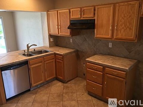 A kitchen with wooden cabinets and a marble countertop.