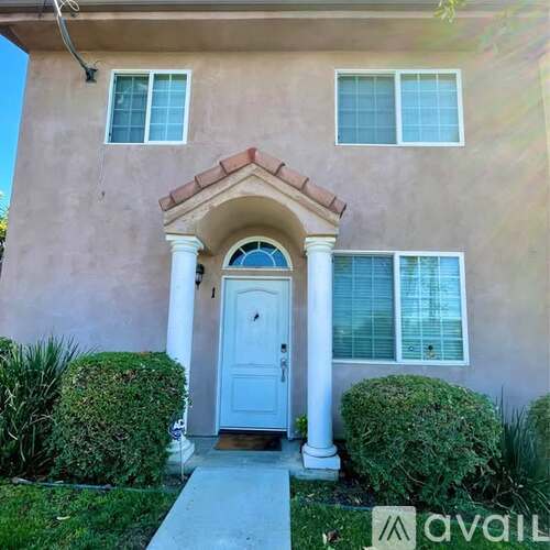 A house with a white door and windows is for sale.