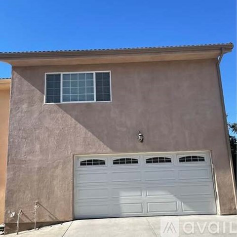 A house with a white garage door and a window above it.